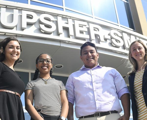 Four people standing outside in front of an office sign that says Upsher-Smith