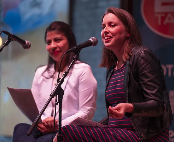 Two EDTalks speakers sitting on the stage speaking into the microphone