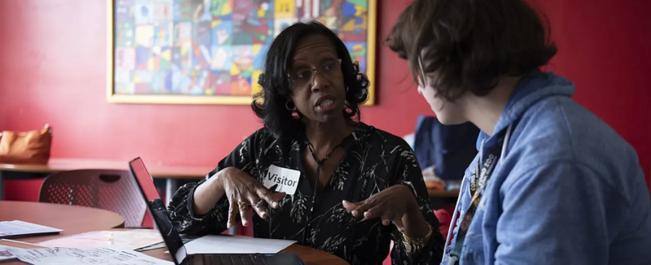 Adult working with student in classroom at table