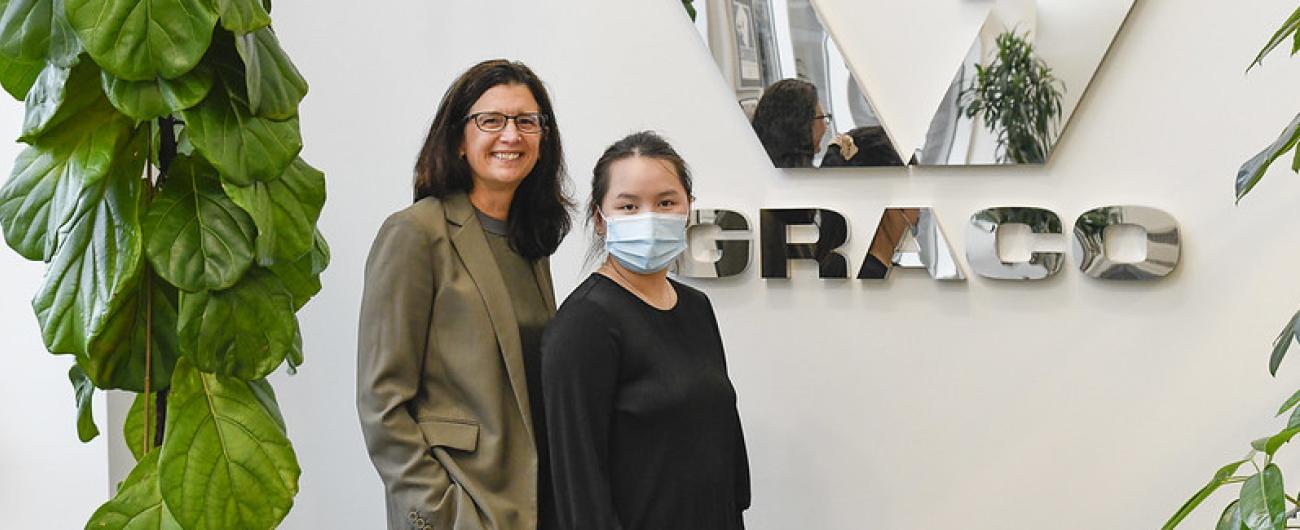 Two people standing in front of Graco logo 