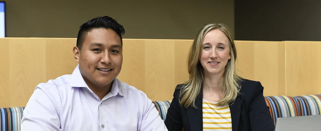 Two people at table with laptops