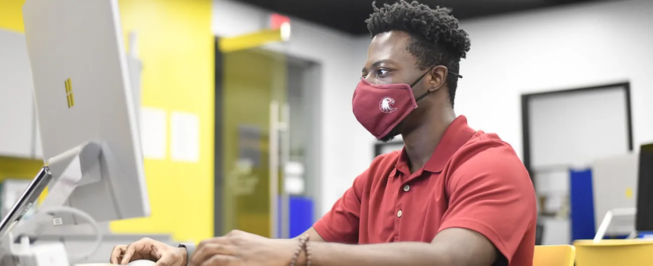Man sitting at a desk working on a computer