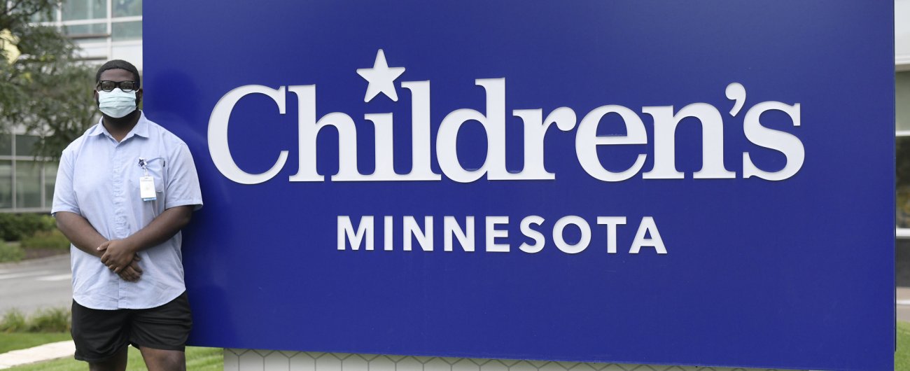 College intern in front of Children's Minnesota sign 
