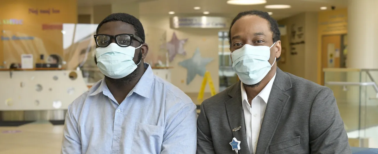 Intern and supervisor sitting together in hospital lobby 