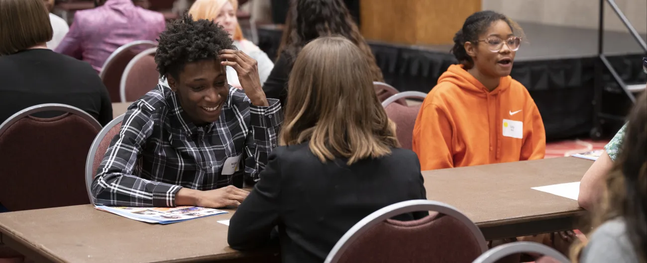 Smiling young person at table