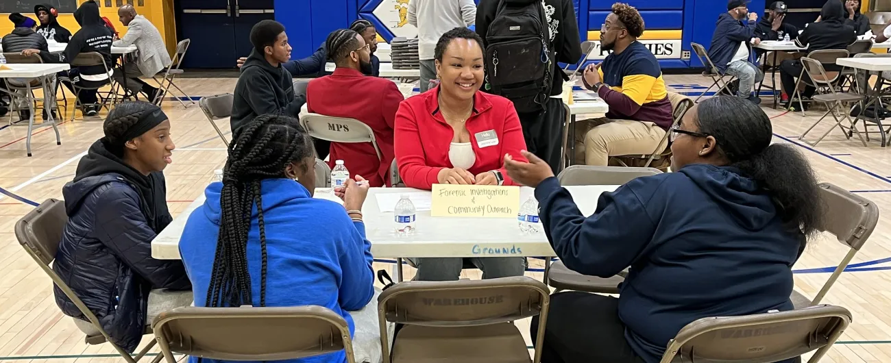 Community volunteer with students in gymnasium
