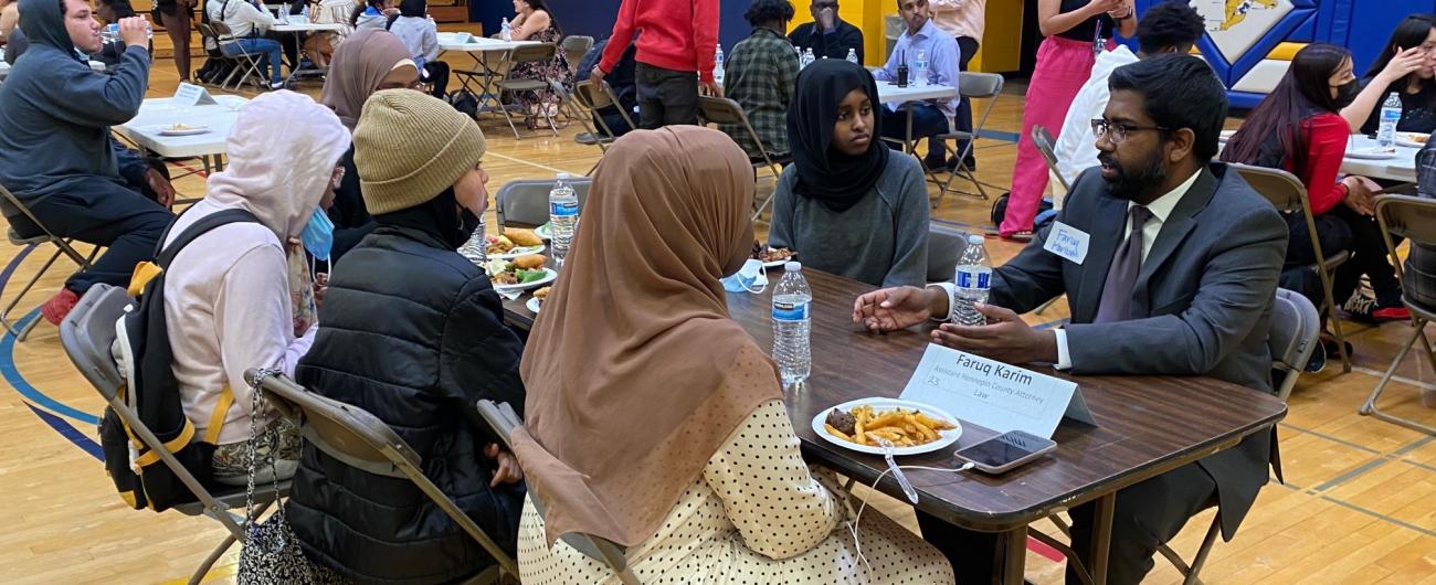 Attorney talking with students at a gym table