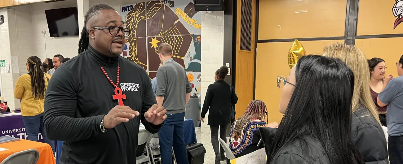 Genysis Works rep talks with students at career fair 